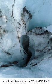 Glacier cave in Iceland with volcanic ash