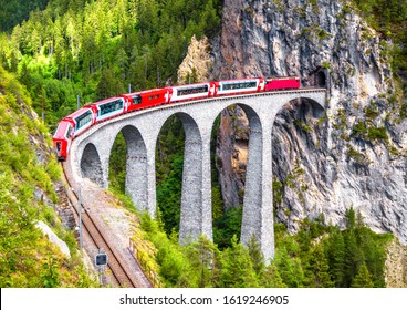 Glacier express train, Switzerland. Red Bernina train on Landwasser Viaduct in Swiss Alps. Aerial view of railway in summer. Landscape with railroad bridge in mountains. Travel, express, nature theme - Shutterstock ID 1619246905