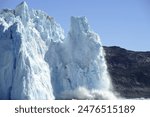 Glacier from the Greenlandic ice sheet melting and droopping icebergs into the ocean, a proces called calving. Eqi glacier neer Ilulissat, western Greenland.