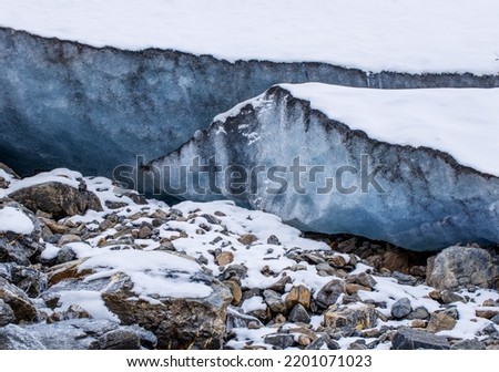 Glacier high in the mountains. A high layer of ice permafrost on a mountain peak. High quality photo.