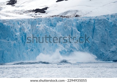 Glacier ice wall breaking off near Antarctic peninsula