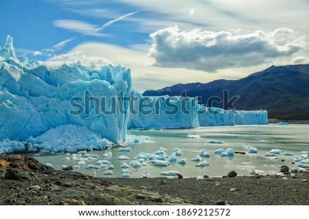 glacier ice wall on the lake and mountains