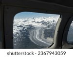 Glacier seen from small airplane in Lake Clark Pass, Alaska. Dark debris lines called lateral or medial moraines along the edges and down the center of glacier. 