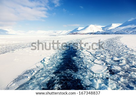 Glacier with small iceberg at the Arctic North Pole, Svalbard.In background is Longyearbyen city 