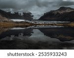 Svínafellsjökull Glacier surrounded by rugged mountains with its reflection from lagoon in Iceland