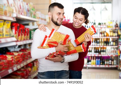 Glad Adults Reading Lable Of Pasta At Supermarket