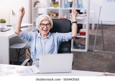 Glad aged businesswoman expressing positivity at work