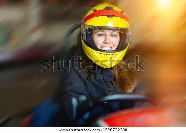 Glad cheerful positive  woman\
driving sport car for karting  in a circuit lap in sport\
club