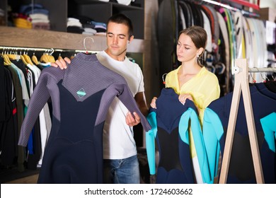  Glad Couple Choosing Diving Suit In Clothing Store