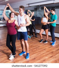 Glad Dancing Couples Learning Salsa At Dance Class