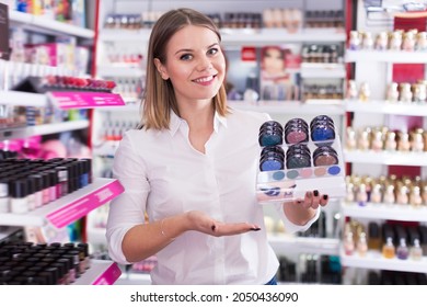 Glad Female Seller Showing Eyeshadows In Cosmetics Shop