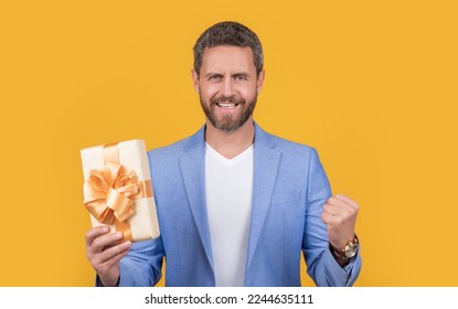 glad guy with present box for holiday. photo of guy holding occasion present box.