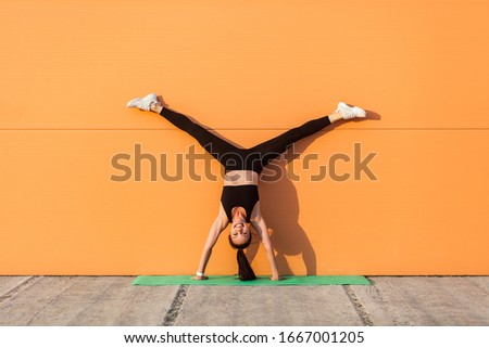 Similar – Woman doing a handstand on the beach