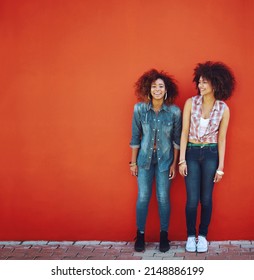 So Glad I Have Her In My Life. Shot Of Two Young Friends Posing In Front Of A Red Wall.