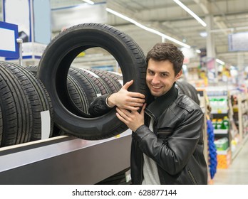 Glad Male Customer Buying New Tires In The Supermarket. He Looks Happy