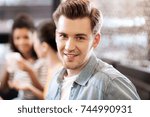 Glad man smiling and sitting at the table