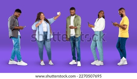 Glad millennial african american people in casual chatting on smartphone, taking selfie on violet background, studio, panorama, full length. Device for blog and social networks, app and great news