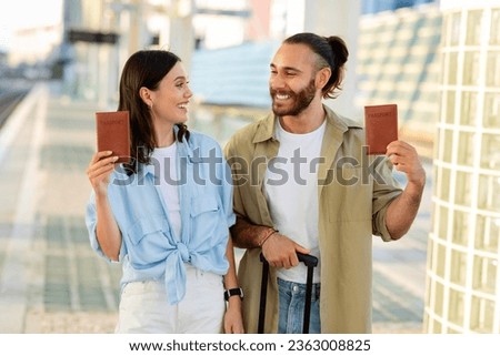 Glad millennial caucasian man and lady with suitcase show passports, enjoy trip, immigration at airport, train station. Travel together, relationships and romance, summer vacation tour