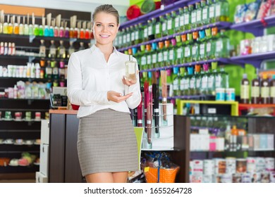 glad saleswoman offering new fragrance in perfume shop