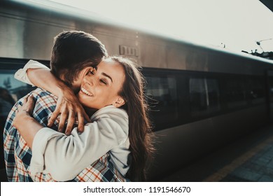 I Am Glad To See You My Friend. Happy Lady Embracing Cheerful Male On Platform Near Train