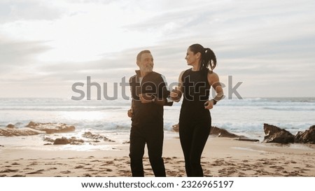 Glad senior caucasian family in sportswear jogging, enjoy training and active lifestyle on beach in morning, outdoor, panorama. Body care, relationships, weight loss together