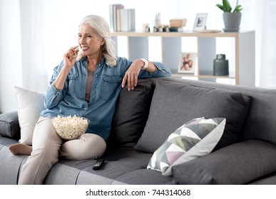 Glad Senior Woman Watching Tv At Home