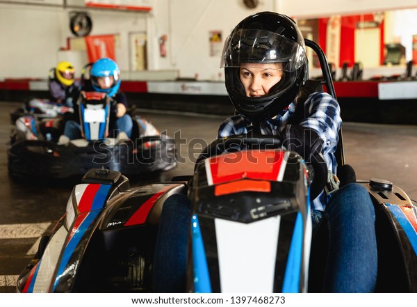 Glad  smiling woman driving sport car for\
karting  in a circuit lap in sport\
club