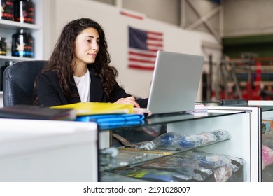 Glad Sports Psychologist Smiling And Browsing Data On Netbook While Sitting At Desk During Work In Gym In Daytime