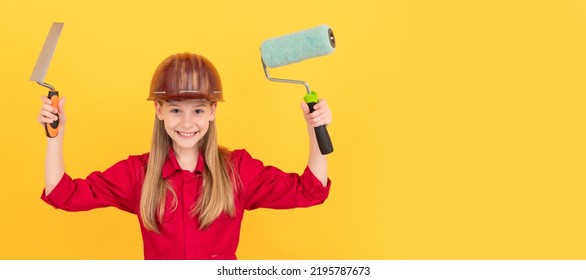 Glad Teen Child In Builder Hard Hat With Paint Roller And Spatula On Yellow Wall. Child Builder In Helmet Horizontal Poster Design. Banner Header, Copy Space.