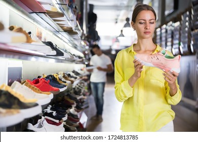 Glad Woman Choosing Sneakers In Streetwear Store