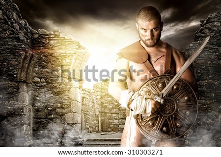 Gladiator or warrior posing with shield and sword outdoors ready for battle