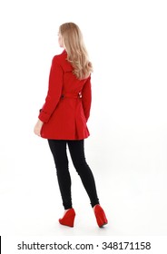  Glamorous, Beautiful Blonde Young Woman With Blonde Hair, Wearing  Long, Red Winter Trench Coat.  Full Length Standing Portrait,  Back View, Walking Away From Camera. Isolated On White Background.