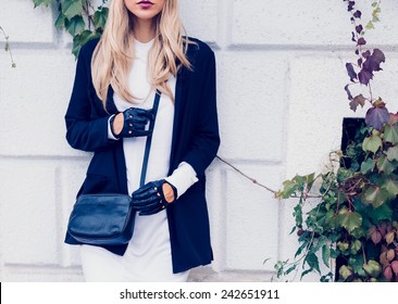 Glamorous Blonde standing at the wall. Urban fashion black and white  style