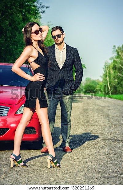 Glamorous couple near the car. Beauty, fashion.\
Love concept.