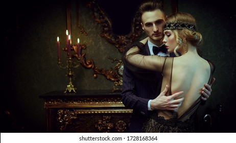 Glamorous passionate couple of a man and a woman in the style of 1920s. Fashion clothes, make-up and hair in luxurious retro style.