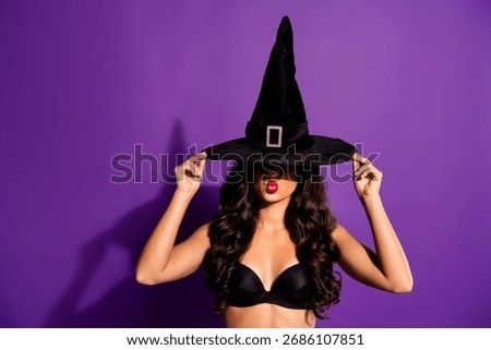 Glamorous witch in a stylish hat posing confidently against a vibrant purple backdrop, embodying Halloween spirit and fashion