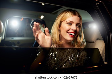 Glamorous Woman Waving Through The Window Of A Limousine