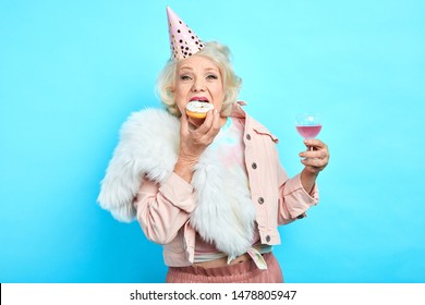 glamour crazy funny grandmother in stylish clothes celebrating her anniversary alone. close up portrait. isolated blue background. studio shot - Powered by Shutterstock
