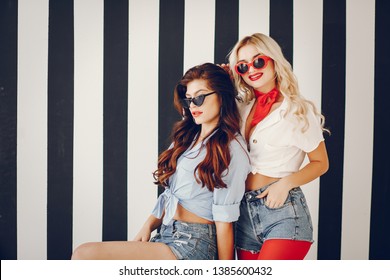 Glamour girls in a studio. Pretty brunette in a pin up clothes. Lady in a sunglasses