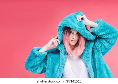 Glamour Model Posing In Lace Bodysuit And Trendy Blue Fur Coat, Isolated On Pink