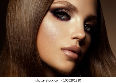 Glamour Portrait Of Beautiful Girl Model With Makeup And Romantic Hairstyle. Fashion Shiny Highlighter On Skin, Sexy Gloss Lips Make-up And Dark Eyebrows.