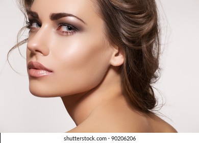 Glamour portrait of beautiful woman model with fresh daily makeup and romantic wavy hairstyle. Fashion shiny highlighter on skin, sexy gloss lips make-up and dark eyebrows
