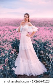 Glamour woman bride fashion model. white long vintage wedding dress. Princess medieval lady in elegant bridal clothes trendy boho style. Meadow pink flowers. spring nature flowering blooming field