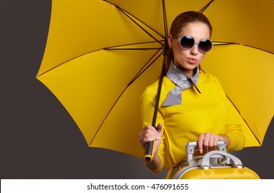 Glamour Woman Under Yellow Umbrella And Suitcase