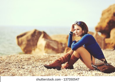 glamourous portrait of the young beautiful woman  in leather boots on the bank of a beach - Powered by Shutterstock