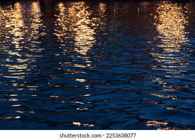Glare of night city lights on the water ripple. City lights. Lantern light. Sea ripple. - Powered by Shutterstock