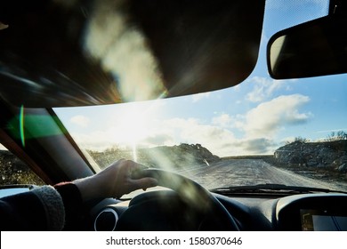 Glare On The Car Front Window And View On Nature Landscape With Road, Water And Grass In Summer Day