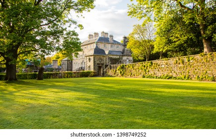 Glasgow Pollok Country Park, Scotland - 04 May 2019: Diagonal Look Through Square Grass Area At Pollock House In Glasgow Behind Trees