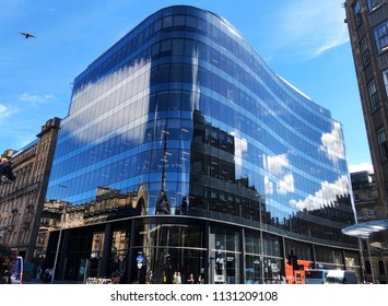 GLASGOW, SCOTLAND – JULY 08 2018: Redeveloped Building In Merchant City Area Of Glasgow With Its Sleek Contemporary Curved Blue Glass Facade Provides Office Retail And Leisure Space