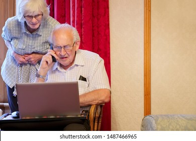 Glasgow, Scotland / UK - August 16th 2019: Senior Elderly Couple At Pc Laptop And On Phone For Help Following Cyber Email Virus Attack For Bank Fraud